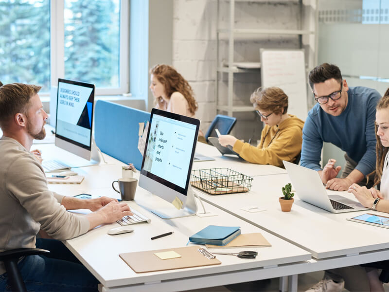 Dozent gibt Feedback in einer Schulung zu digitalem Marketing in kleinen Gruppen